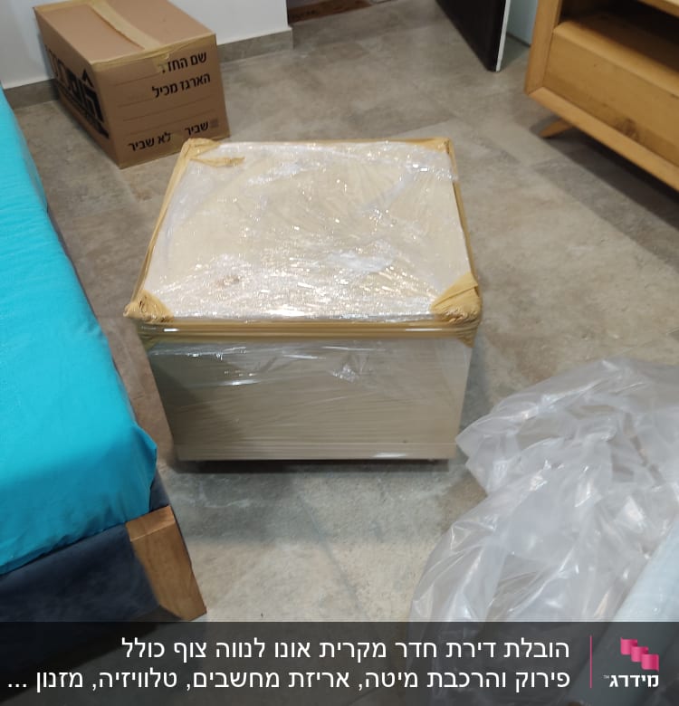 קופסה עטופה בניילון, קרטון אריזה, גליל ניילון על הרצפה
